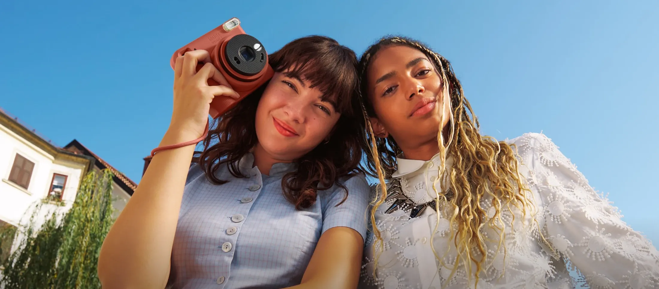 Две девушки с красной камерой instax SQUARE 2 на прогулке